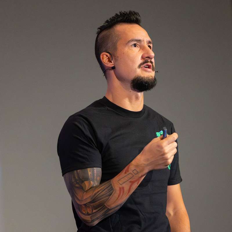 Photo of Nicolai standing with crossed arms, looking at the camera